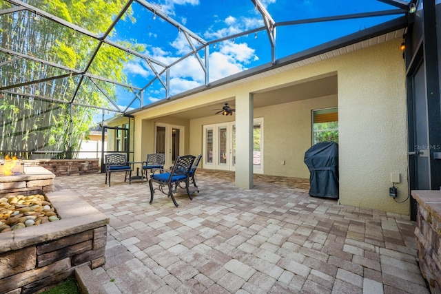 view of patio with a grill, glass enclosure, ceiling fan, and french doors