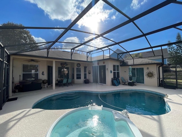 view of swimming pool featuring an in ground hot tub, ceiling fan, a patio area, and glass enclosure