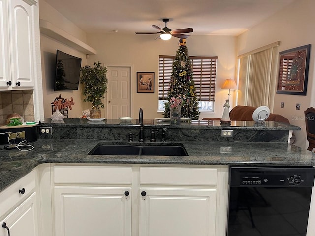 kitchen with dark stone countertops, black dishwasher, sink, and white cabinets