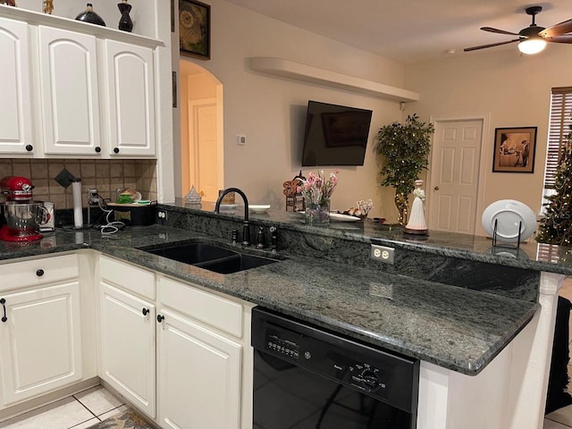 kitchen with sink, white cabinetry, light tile patterned floors, dishwasher, and dark stone counters