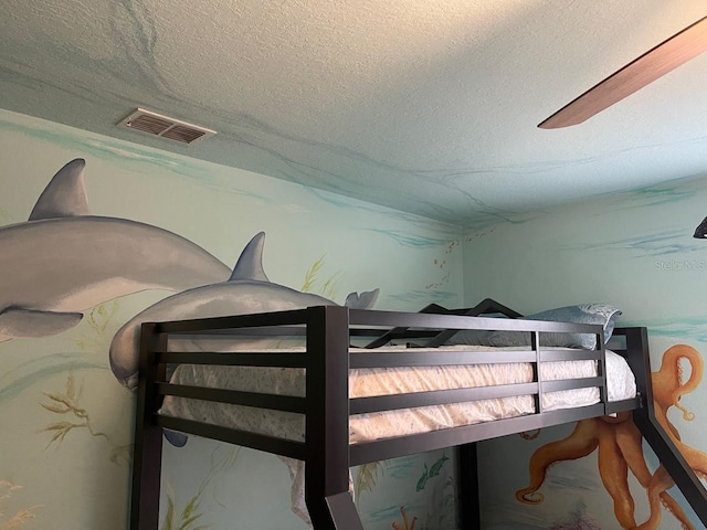 bedroom featuring a textured ceiling and ceiling fan