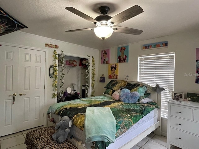 tiled bedroom with a textured ceiling and ceiling fan