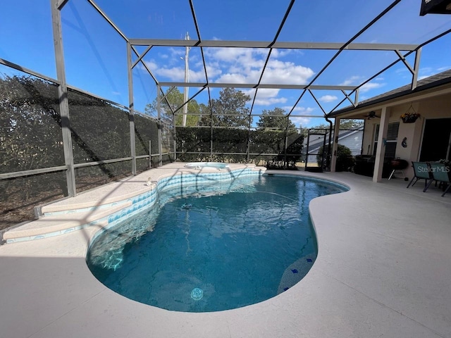 view of pool with a patio and glass enclosure