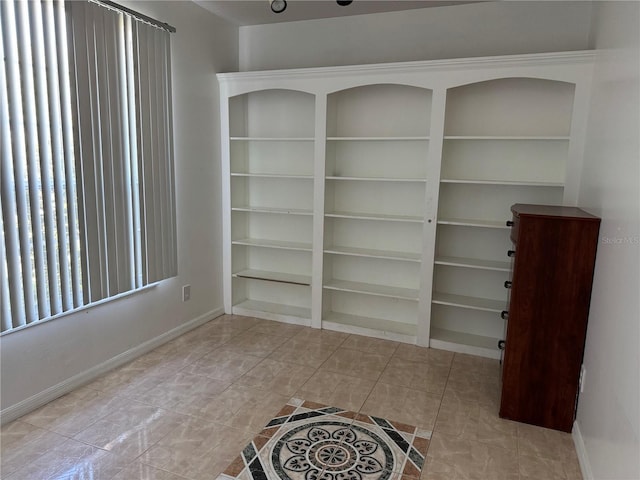 unfurnished room with baseboards