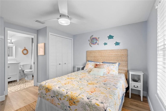 bedroom featuring connected bathroom, light hardwood / wood-style flooring, a closet, and ceiling fan