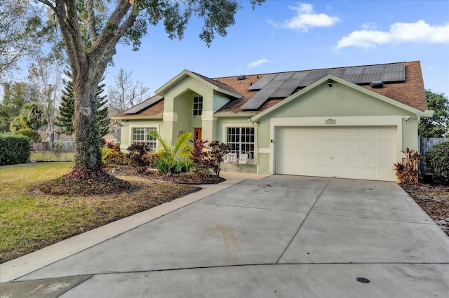 single story home with a garage and solar panels