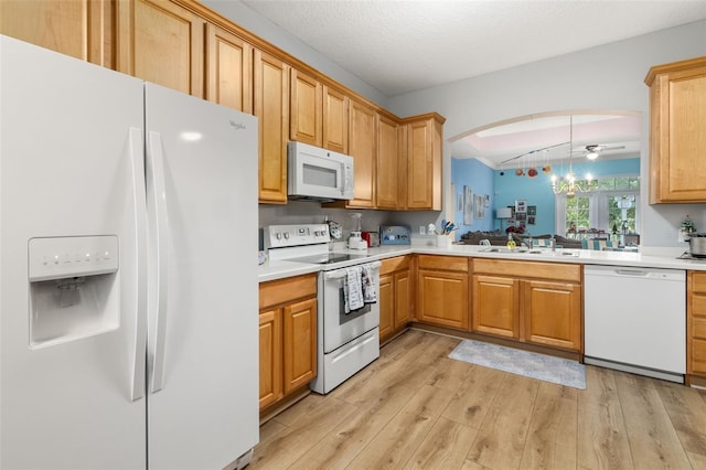 kitchen featuring pendant lighting, white appliances, a textured ceiling, sink, and light hardwood / wood-style flooring