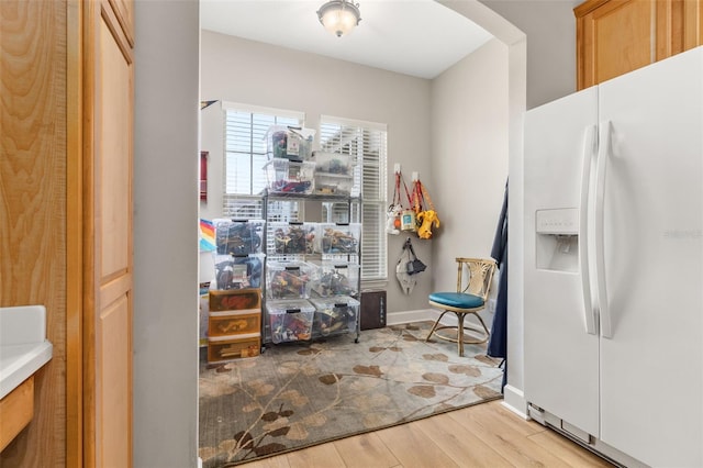 kitchen with white refrigerator with ice dispenser and light hardwood / wood-style flooring