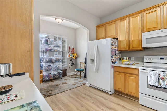 kitchen with white appliances and light hardwood / wood-style flooring