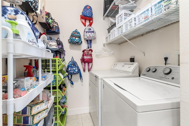 clothes washing area with washing machine and clothes dryer and light tile patterned floors