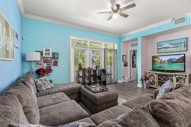 living area with visible vents, ornamental molding, ceiling fan, and wood finished floors