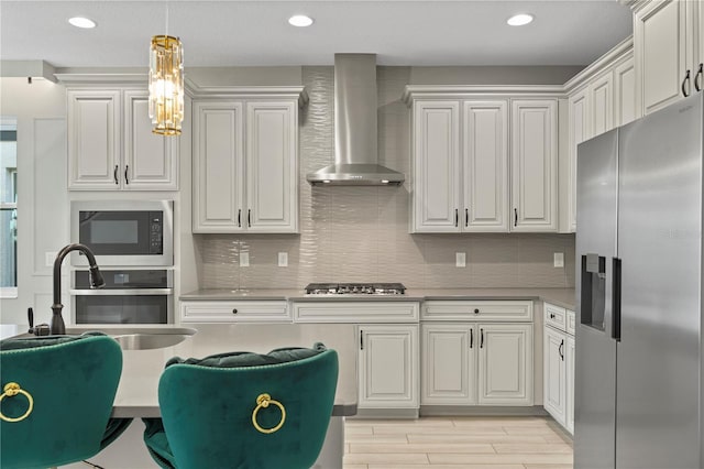 kitchen featuring white cabinetry, appliances with stainless steel finishes, sink, and wall chimney exhaust hood