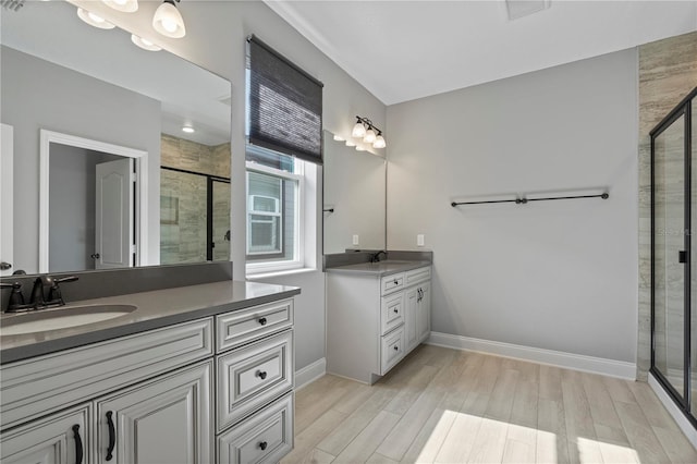 bathroom featuring walk in shower, wood-type flooring, and vanity