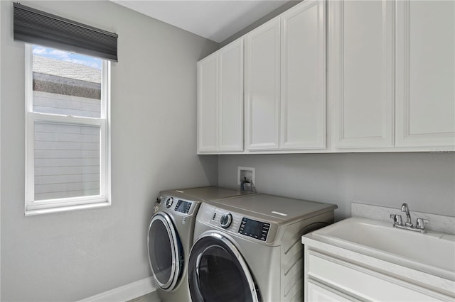 laundry room with cabinets, washing machine and clothes dryer, and sink