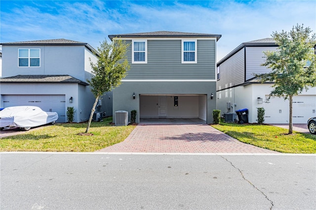 front of property featuring cooling unit, a garage, and a front lawn