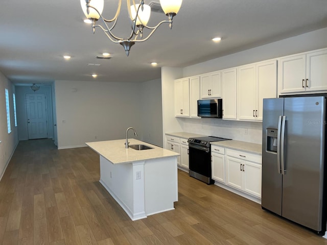 kitchen featuring stainless steel appliances, a kitchen island with sink, decorative light fixtures, white cabinets, and sink