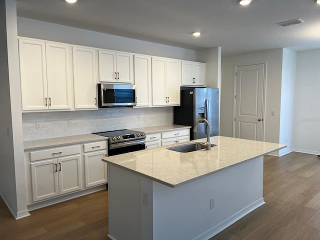 kitchen with sink, white cabinets, stainless steel appliances, and an island with sink