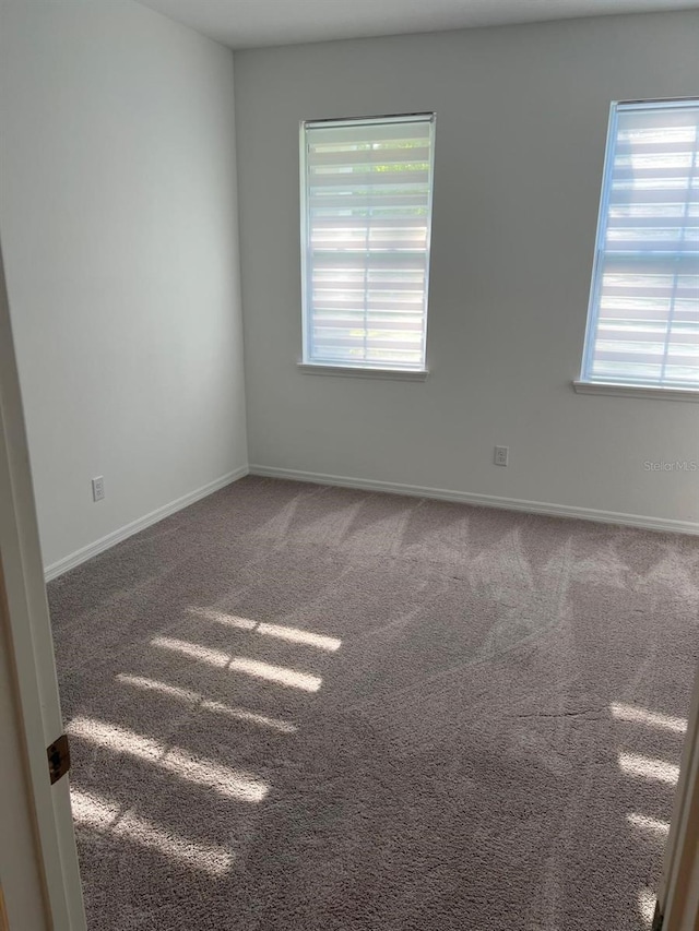 unfurnished room with a wealth of natural light and carpet