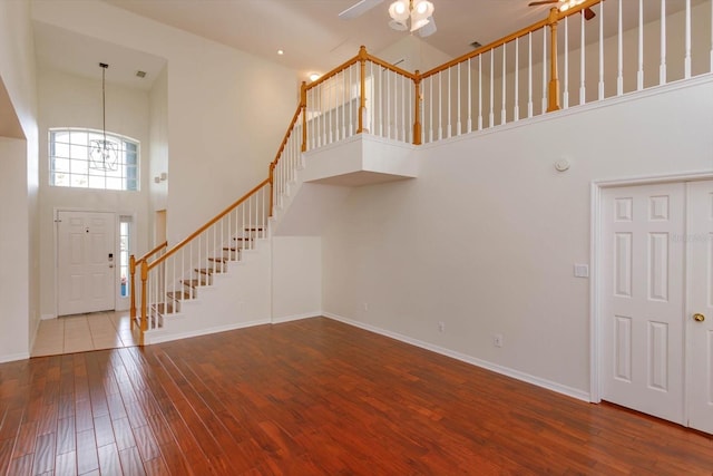 entryway featuring a towering ceiling, ceiling fan, and hardwood / wood-style flooring