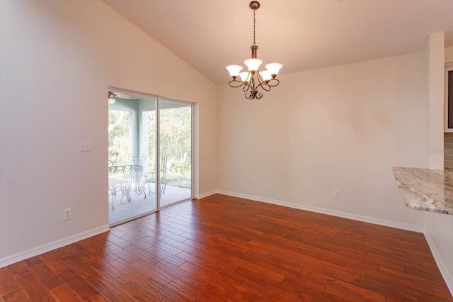 empty room featuring high vaulted ceiling, dark hardwood / wood-style flooring, and a chandelier