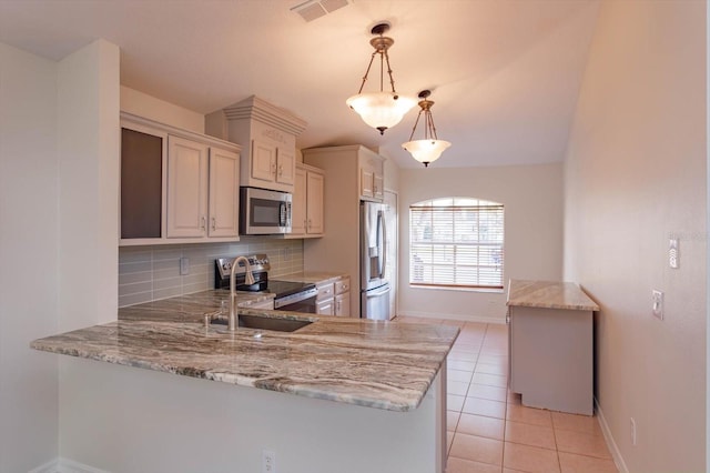 kitchen with decorative light fixtures, decorative backsplash, kitchen peninsula, and appliances with stainless steel finishes