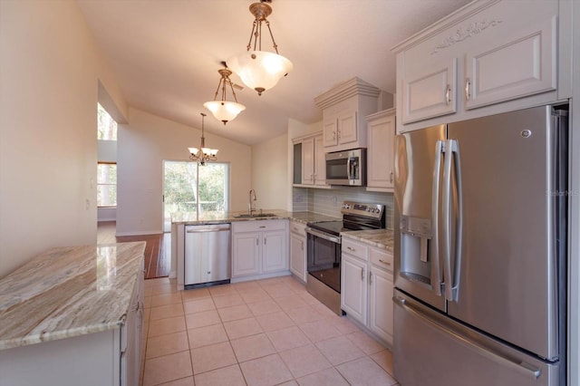 kitchen with white cabinetry, hanging light fixtures, appliances with stainless steel finishes, and lofted ceiling