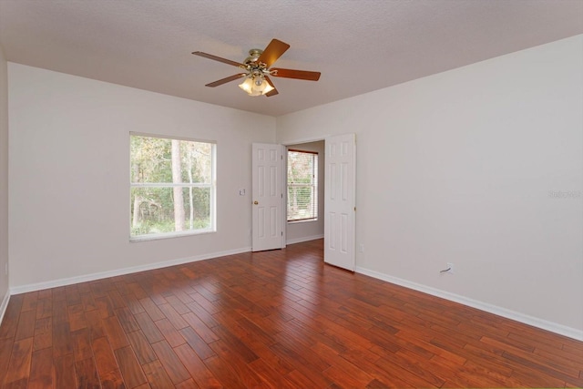 empty room featuring a textured ceiling, dark hardwood / wood-style floors, and ceiling fan