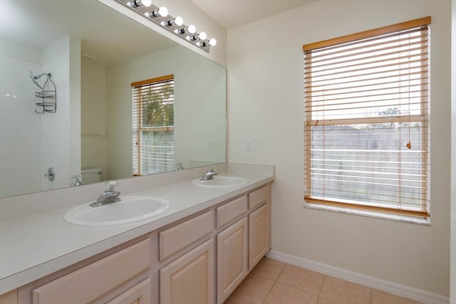 bathroom with tile patterned floors, a wealth of natural light, toilet, and vanity