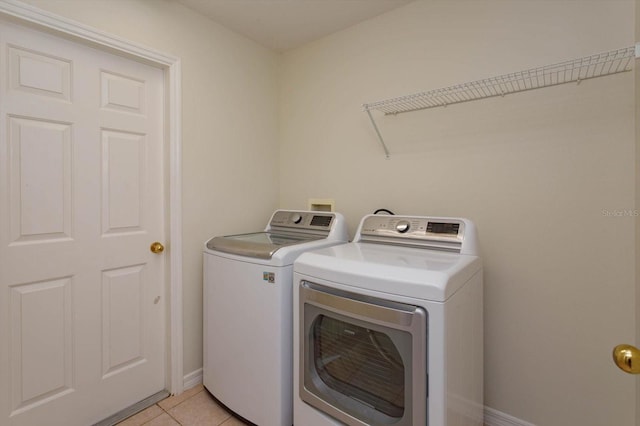 laundry area featuring washer and clothes dryer and light tile patterned floors