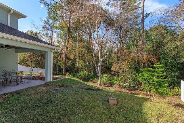 view of yard with ceiling fan and a patio