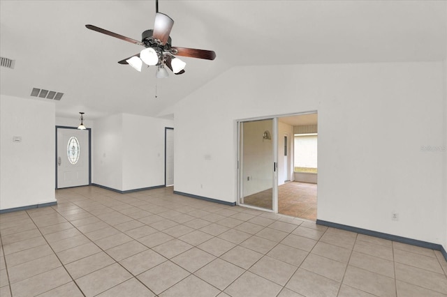 spare room with ceiling fan, vaulted ceiling, and light tile patterned floors