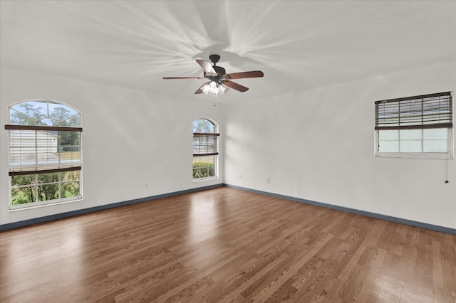 unfurnished room featuring ceiling fan, a healthy amount of sunlight, and wood-type flooring