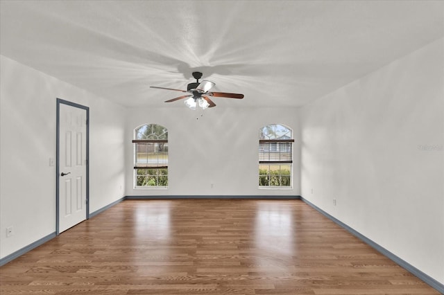 spare room featuring hardwood / wood-style floors, a wealth of natural light, and ceiling fan