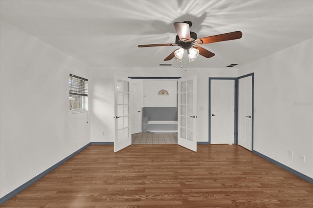 unfurnished bedroom featuring dark wood-type flooring, ceiling fan, and french doors