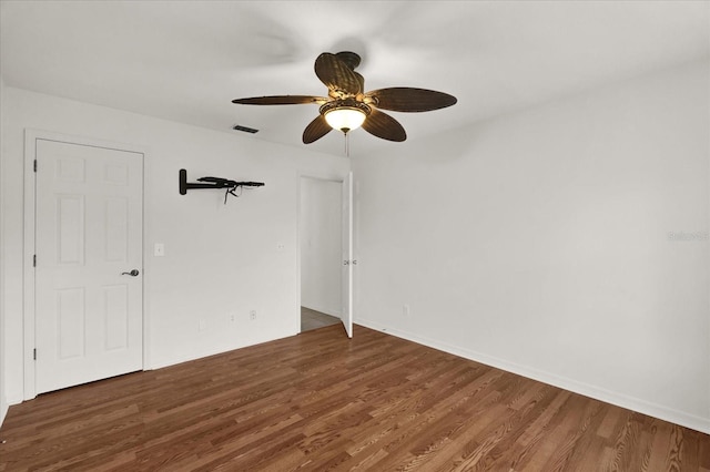 spare room featuring dark wood-type flooring and ceiling fan