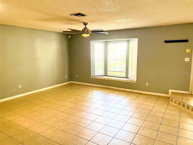 tiled spare room with ceiling fan and a textured ceiling