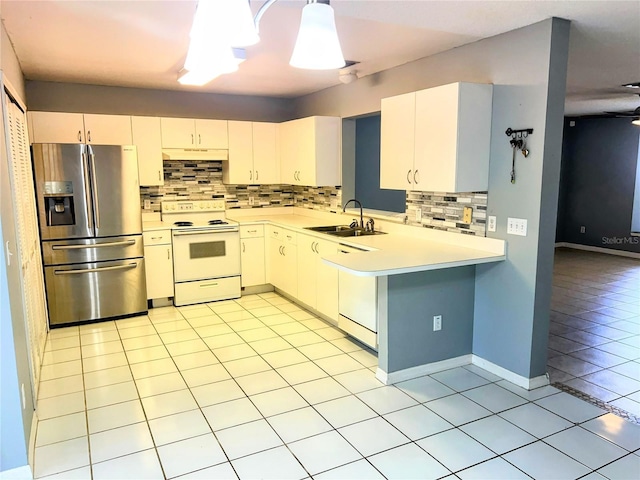 kitchen featuring sink, stainless steel fridge, white range with electric cooktop, white cabinets, and decorative light fixtures