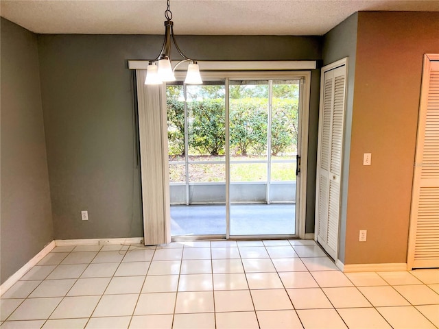 entryway with light tile patterned floors, a chandelier, and a textured ceiling