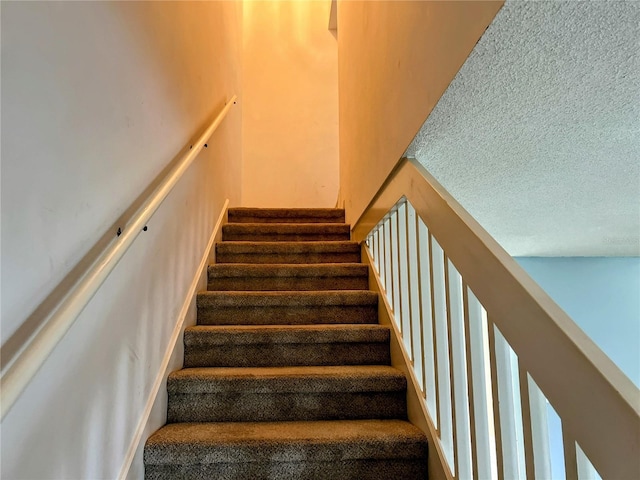 stairs featuring a textured ceiling