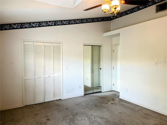 unfurnished bedroom featuring multiple closets, carpet, lofted ceiling, and ceiling fan