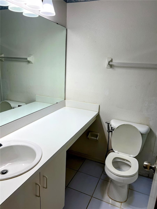 bathroom featuring vanity, tile patterned floors, and toilet