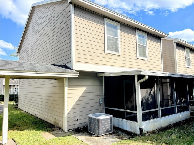 rear view of property with a sunroom and central AC unit