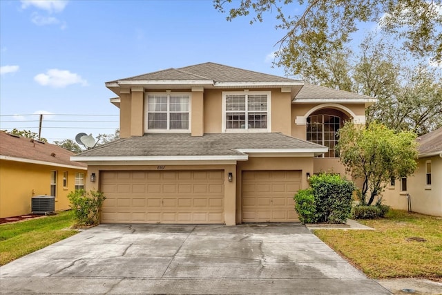 front facade with a garage, cooling unit, and a front yard