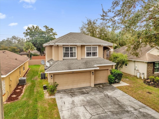 front of property with a garage, central AC unit, and a front lawn