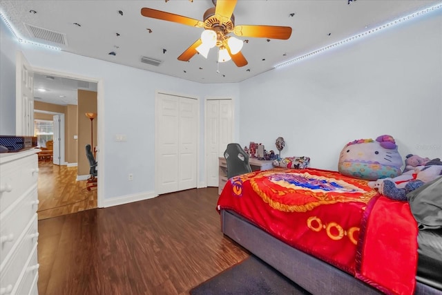 bedroom with dark hardwood / wood-style flooring and ceiling fan