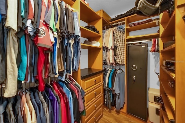 walk in closet with light hardwood / wood-style flooring