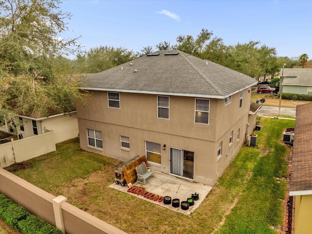 back of property with cooling unit, a patio, and a lawn