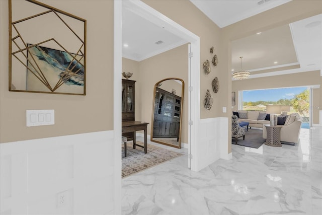 hall featuring ornamental molding and an inviting chandelier