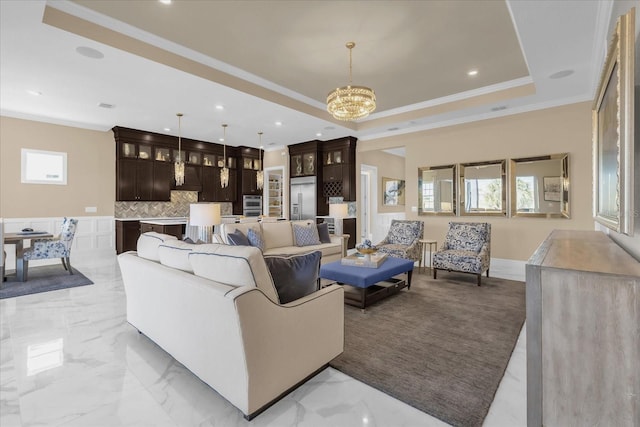 living room featuring a chandelier, crown molding, and a tray ceiling