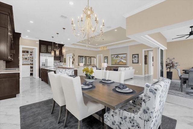 dining area featuring ceiling fan with notable chandelier, a raised ceiling, and crown molding